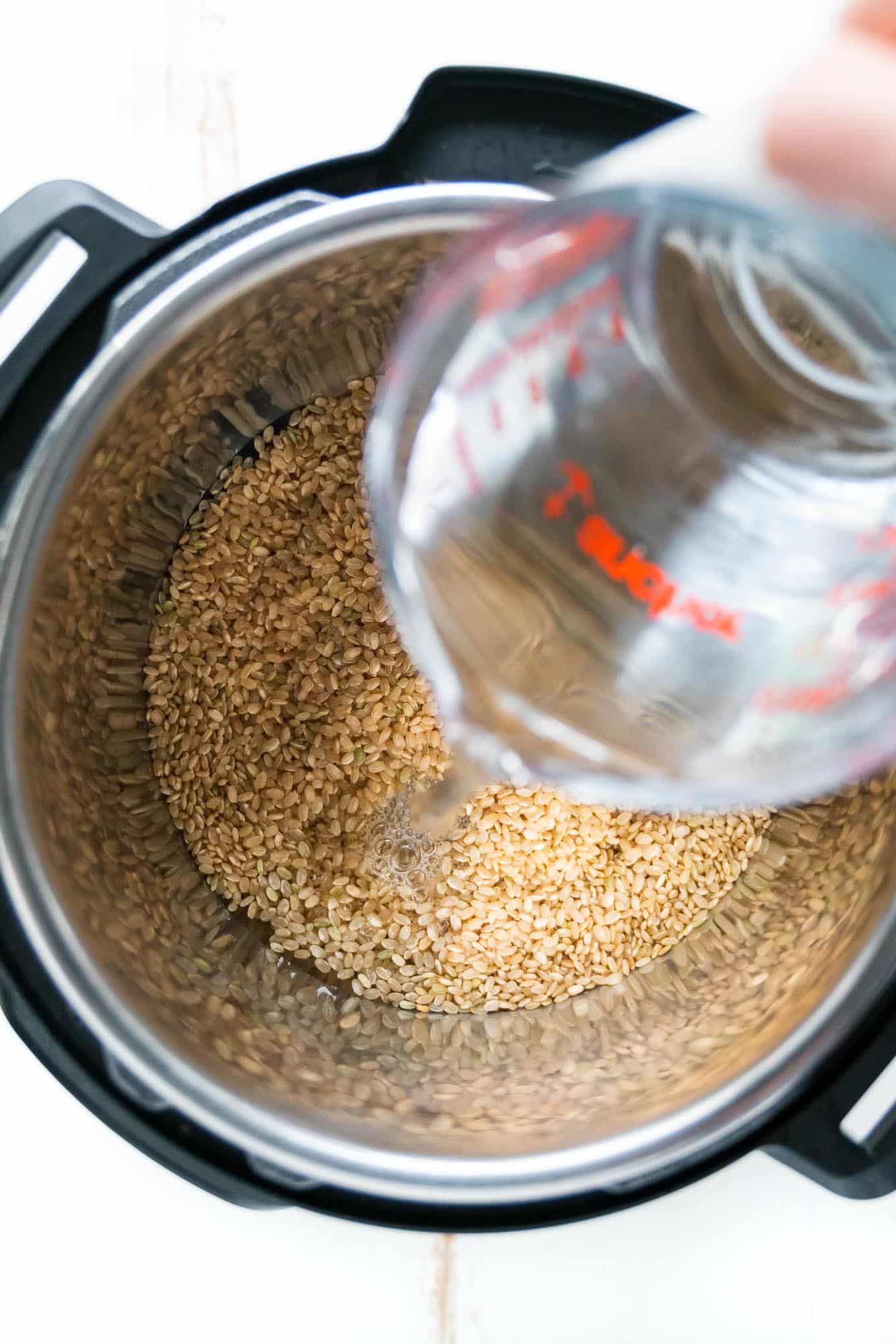 Instant Pot Brown Rice with water pouring into pot