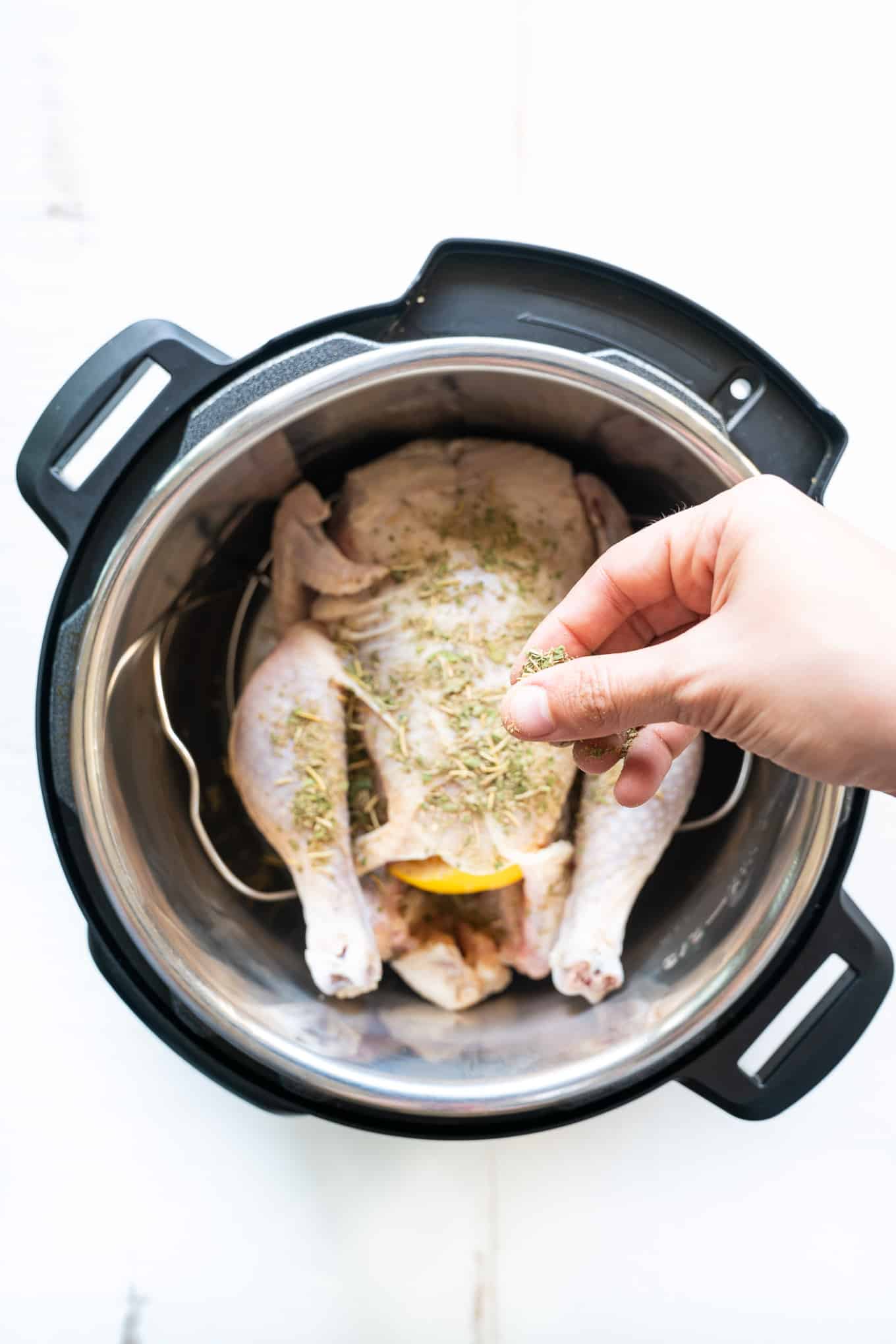 Instant Pot Whole Chicken being seasoned with spice mix