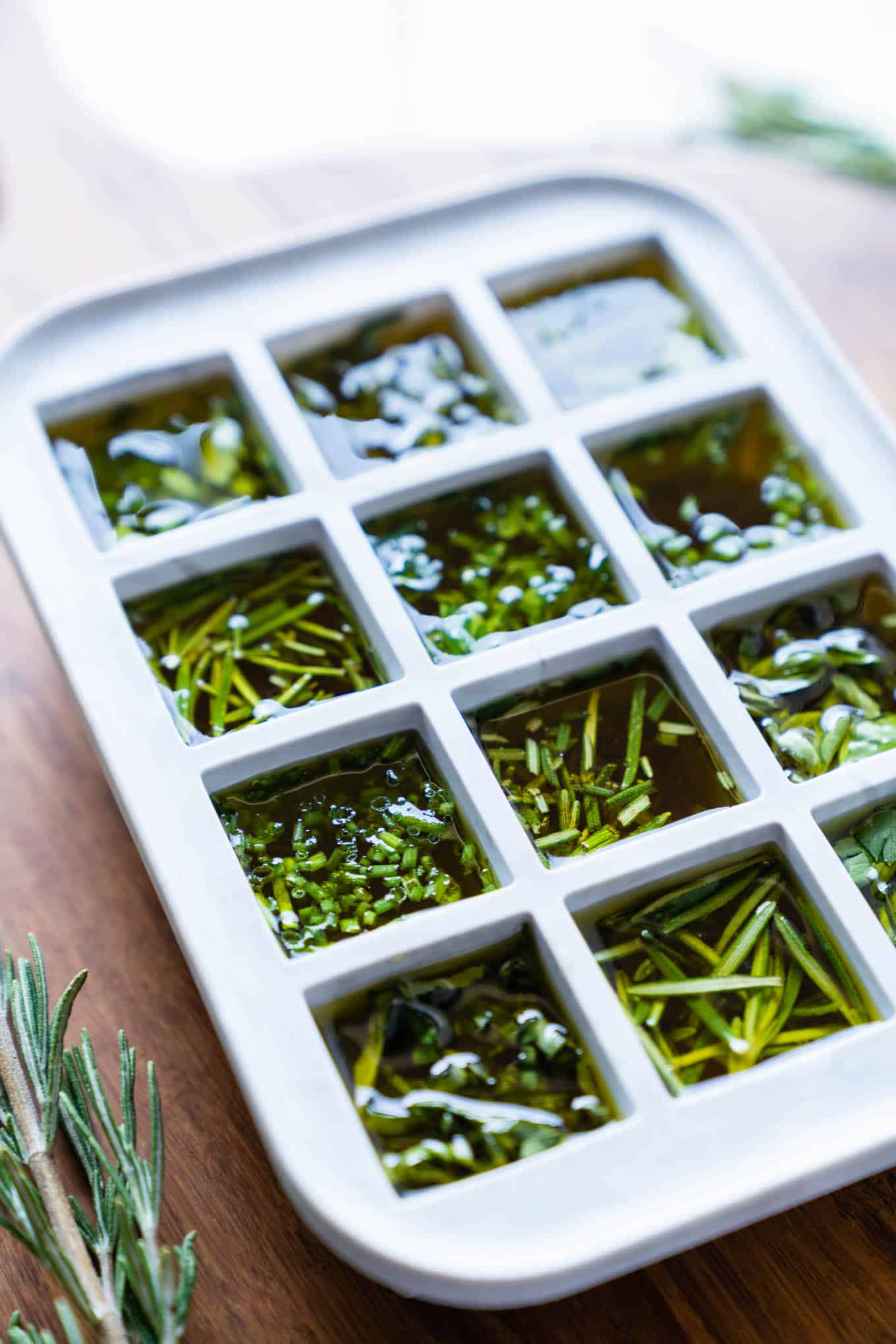 Ice cube mold filled with herbs and olive oil