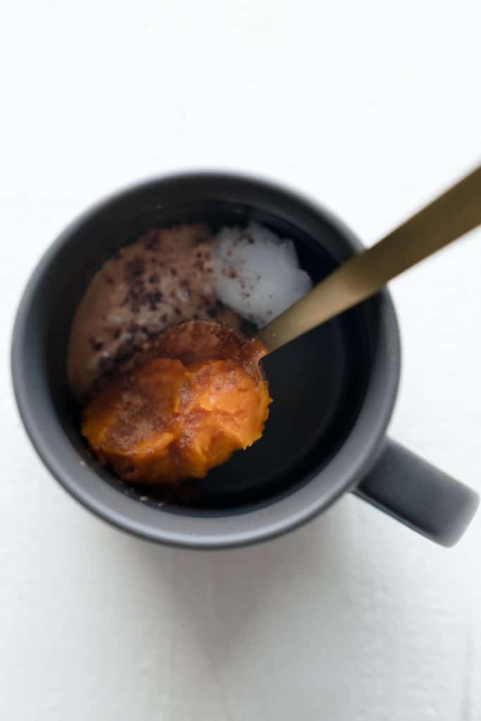 Top down shot of mug with pumpkin puree and gold spoon