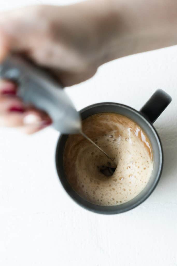 latte whisk in a black mug filled with coffee
