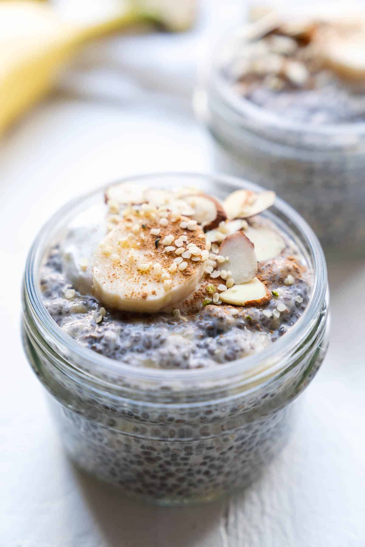 Closeup of a banana chia pudding topped with sliced almonds.