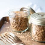 Two jars of nut free granola with a gold spatula in the front.